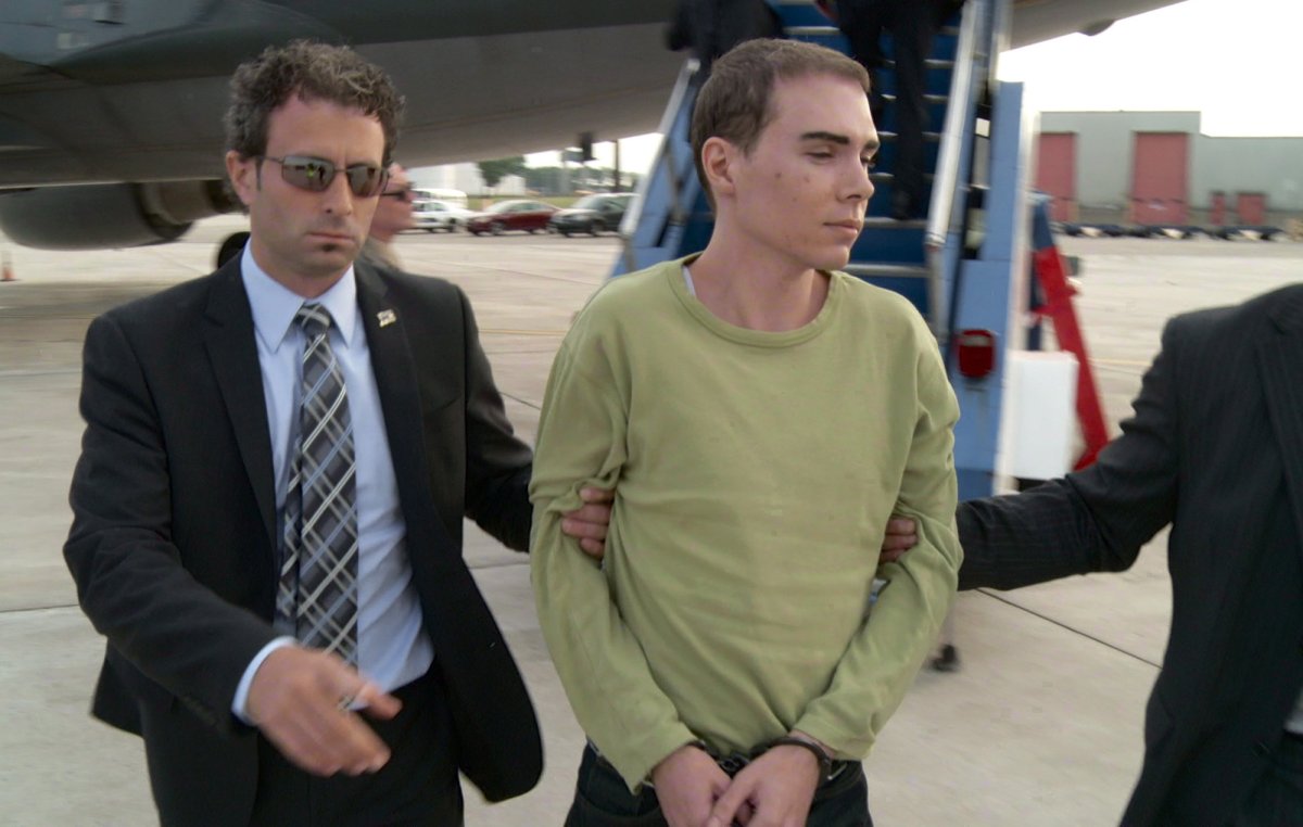 Luka Rocco Magnotta is taken by police from a Canadian military plane to a waiting van on Monday, June 18, 2012 in Mirabel, Quebec. 