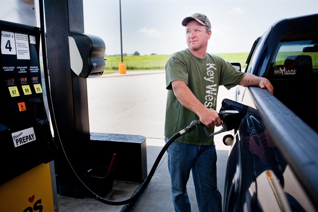 FILE - In this July 1, 2014 file photo, Lance Thompson pumps gas into his truck at a Love's station in St. Joseph, Mo. The Labor Department reports on U.S. consumer prices in August on Wednesday, Sept. 17, 2014. (AP Photo/St. Joseph News-Press, Sait Serkan Gurbuz, File)