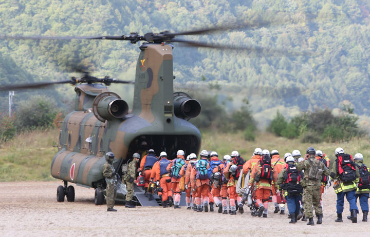 Rescue workers board a defense force helicopter heading for the top of Mount Ontake during a search operation on October 1, 2014 following a September 27 volcanic eruption near Otaki village in Nagano prefecture.