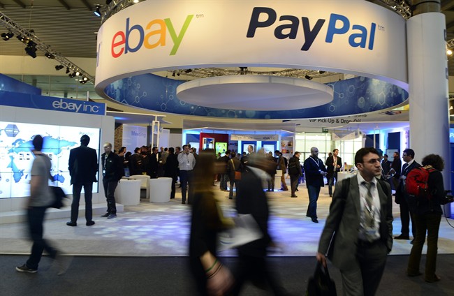 Attendees walk in front of an EBay and PayPal display area at the Mobile World Congress, the world's largest mobile phone trade show, in Barcelona, Spain. PayPal is splitting from EBay Inc. and will become a separate and publicly traded company during the second half of 2015.