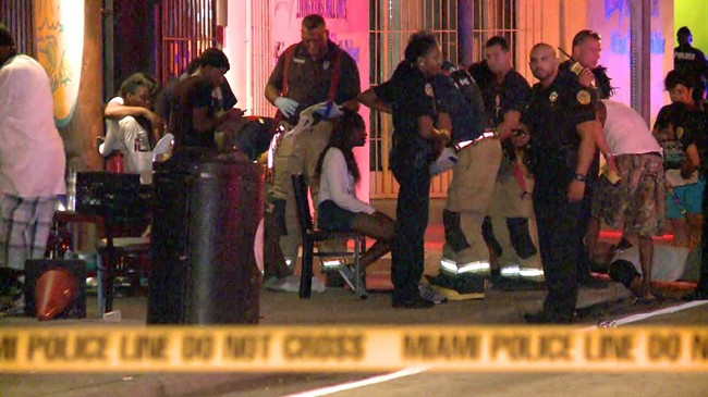 Emergency personnel tend to the wounded outside The Spot, a nightclub in Miami, early Sunday, Sept. 28, 2014. 