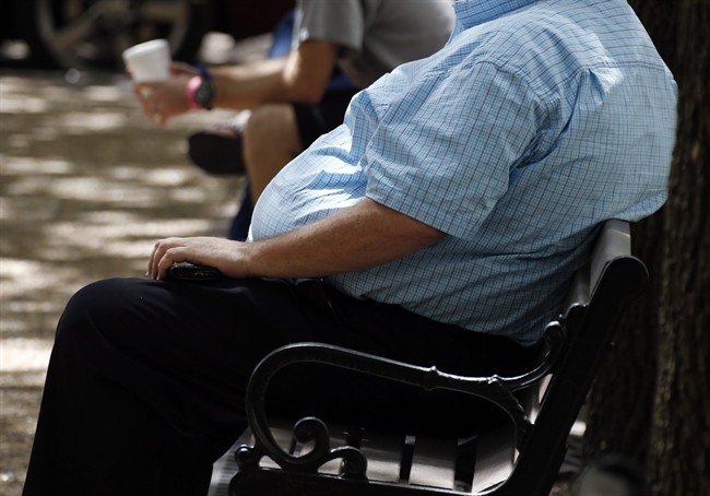 In this Thursday, Sept. 4, 2014, file photo, an overweight man rests on a bench in Jackson, Miss. 