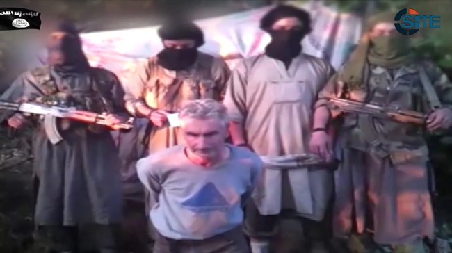 Members of Jund al-Khilafah, or Soldiers of the Caliphate, stand behind French mountaineer Herve Gourdel just before beheading him. 