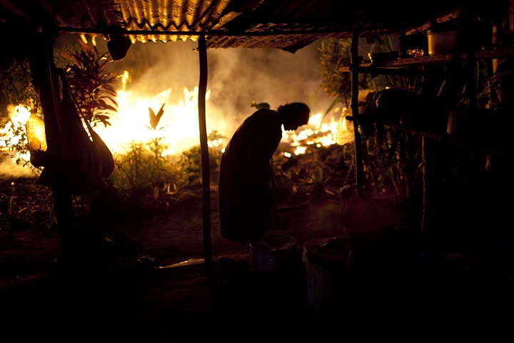 In this Sept. 26, 2013 photo, an Ashaninka Indian woman is silhouetted against a wall of flames caused by burning branches during a land clearing in Otari Nativo, Pichari district, Peru.