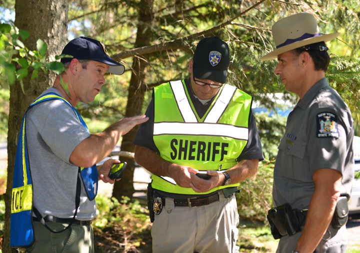 Lancaster Police Chief Gerald Gill, left,  Erie County Sheriffs' Capt. Gregory Savage, center, and New York State Troopers Capt. Steve Graap collect information after a mid-air collision involving two planes in Lancaster, N.Y.,  on Saturday, Sept. 27, 2014.