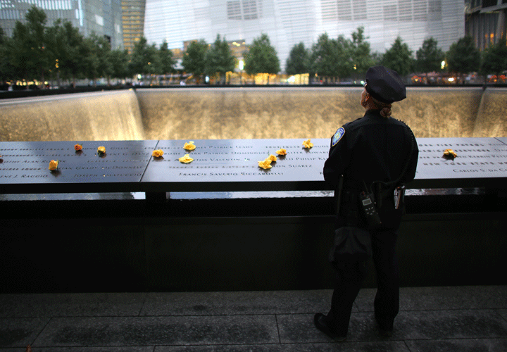 NY-Port Authority Police Officer Donna Przybyszewski spent a moment to think about her colleagues she knew who lost their lives during September 11th attack in 2001, at the South Tower Memorial Pool before memorial observances held at the site of the World Trade Center in New York, Sept. 11, 2014.