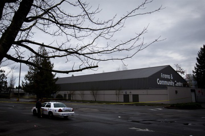 RCMP officers talk outside the Newton Arena in Surrey, B.C., on Monday December 30, 2013, where Julie Paskall was killed.