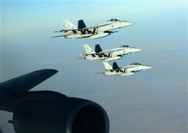 In this Tuesday, Sept. 23, 2014 photo released by the U.S. Air Force, a formation of U.S. Navy F-18E Super Hornets fly over northern Iraq.