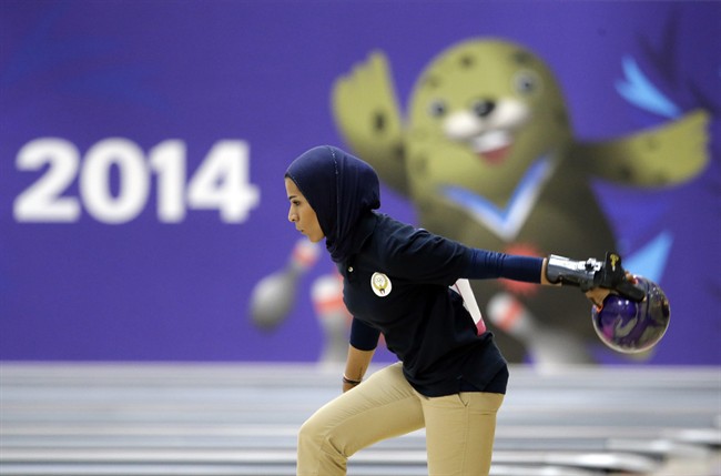 IN this Wednesday, Sept. 24, 2014 file photo, Kuwait's Karam Altaf competes in women's singles squad A bowling competition at Anyang Hogye Gymnasium at the 17th Asian Games in Anyang, South Korea. The Qatar women's basketball team forfeited its Asian Games match against Mongolia after players were refused permission to wear a hijab.