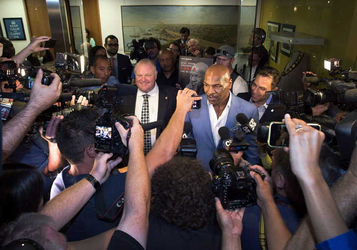 Reporters surround Toronto Mayor Rob Ford, left, and former heavyweight boxing champion Mike Tyson following a closed-door meeting between the two at City Hall in Toronto on Tuesday, September 9, 2014. 
