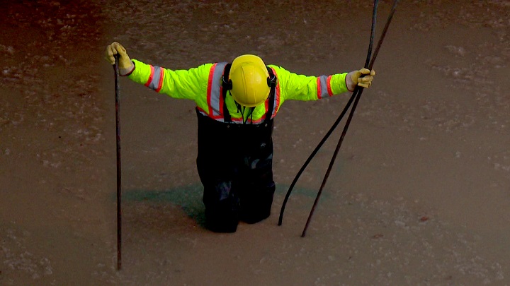 A City of Winnipeg worker investigating a water main break.
