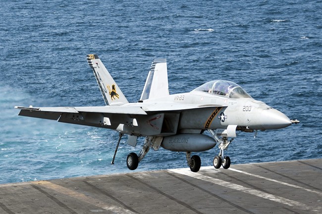 In this image provided by the U.S. Navy a F/A-18F Super Hornet attached to the Fighting Black Lions of Strike Fighter Squadron lands aboard the aircraft carrier USS George H.W. Bush in the Persian Gulf on Tuesday, Sept. 23, 2014, after conducting strike missions against Islamic State group targets in Syria.