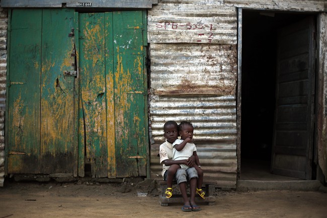 Children sit in from of their home in the St. Paul Bridge neighborhood of Monrovia, Liberia, Sunday Sept. 28, 2014. 