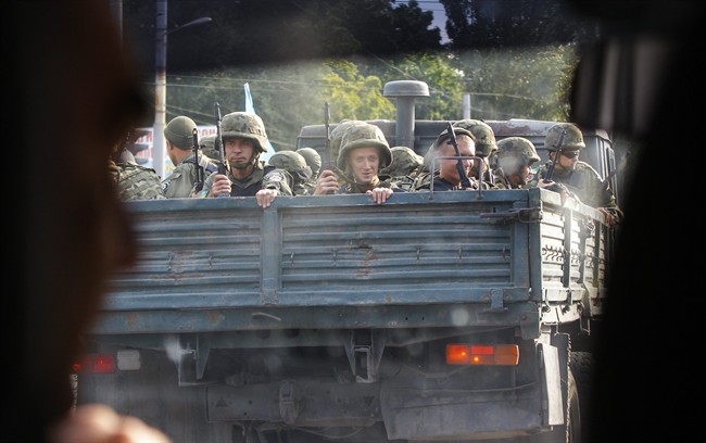 Ukrainian soldiers drive on a truck in the southern coastal town of Mariupol, Ukraine, Monday, Sept. 8, 2014. 