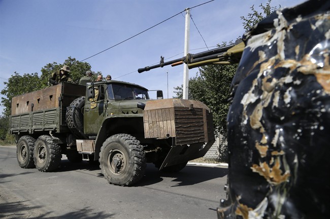 Pro-Russian rebels drive an armored truck in Donetsk, eastern Ukraine, Sunday, Sept. 7, 2014. 
