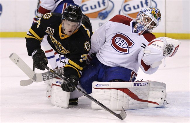 Boston Bruins center Carl Soderberg, left, collides with Montreal Canadiens goalie Peter Budaj, who makes a glove save during the second period of an NHL hockey game, Monday, March 24, 2014, in Boston. The Canadiens have traded Budaj to the Winnipeg Jets in exchange for forward Eric Tangradi .