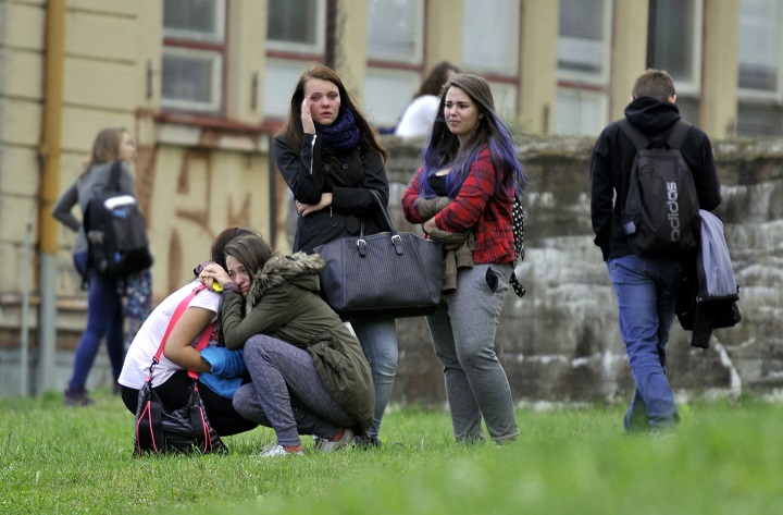 Girls comfort each others near a high school where a woman stabbed and killed a student and injured two other others in Zdar nad Sazavou, 120 kilometers (75 miles) southeast of Prague, on Tuesday, Oct. 14, 2014. Police spokeswoman Jana Kroutilova says the victim was a 16-year old boy. She says the 26-year-old female suspect also injured two teenage girls and a police officer before she was arrested. Police say the suspect was from a different Czech region and it was not immediately clear why she attacked the students. 