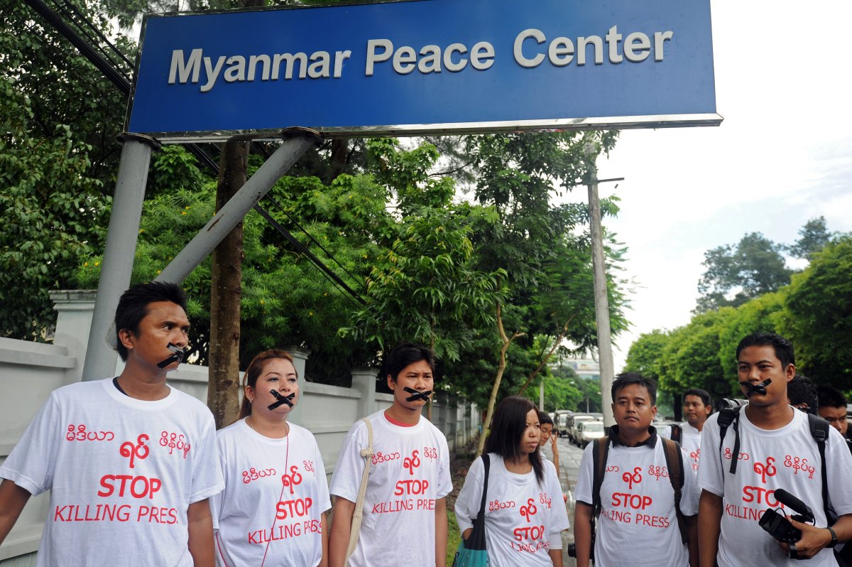 :Myanmar journalists wearing T-shirts that say 'Stop Killing Press' stage a silent protest for five journalists who were jailed for 10 years on July 10, near the Myanmar Peace Center where Myanmar President Thein Sein was scheduled to meet with local artists in Yangon on July 12, 2014.