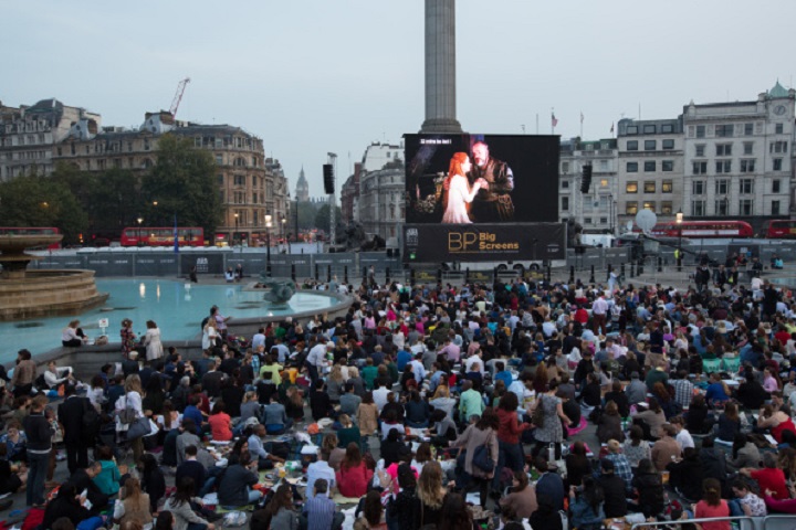 Members of the public prepare to watch a performance of Verdi's opera 'Rigoletto' on a big screen in Trafalgar Square displaying a live relay from The Royal Opera House on September 17, 2014 in London, England.