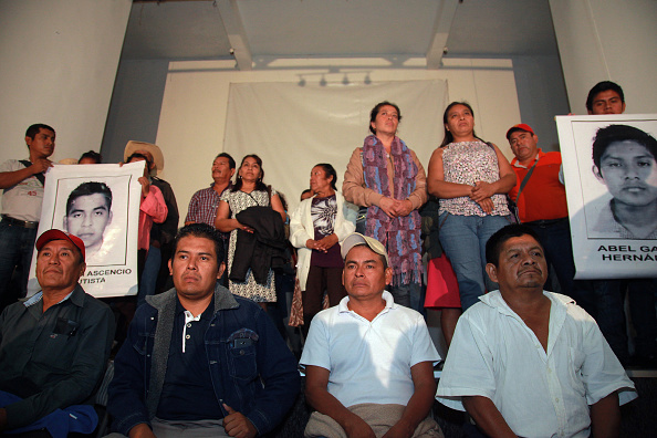 Parents and relatives of 43 missing students hold the pictures of the students during the conference at the Miguel Agustin Pro Juarez Human Rights Center, after a meeting with President Enrique Pena Nieto at the Official Home of Los Pinos after a month over the missing of 43 students in Iguala, Guerrero, October 29, 2014 in Mexico City, Mexico.