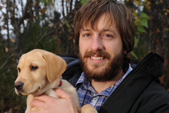 Justin Priest holds his 9-week-old yellow lab Lily in Anchorage on Thursday, Oct. 9, 2014. 