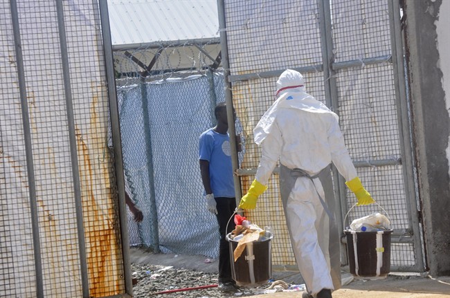 A Ebola health worker removes rubbish including plastic bottles from the Island Clinic Treatment center in Monrovia, Liberia, Wednesday, Oct. 29, 2014. 