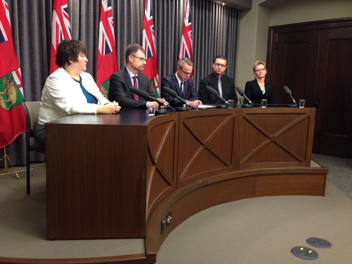 Manitoba education minister James Allum (centre) at a news conference Tuesday.