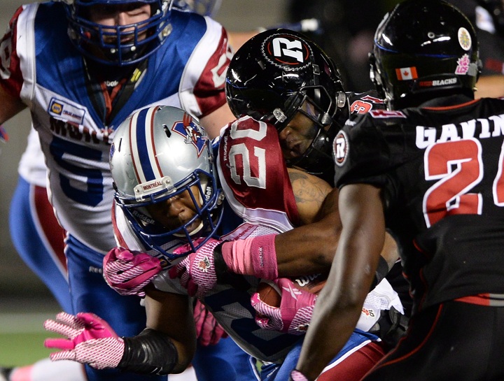 Ottawa Redblacks' Jasper Simmons tackles Montreal Alouettes' Tyrell Sutton during CFL action in Ottawa on Friday Oct 24, 2014.