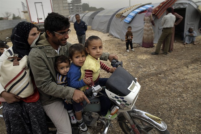 Syrian Kurdish refugees who fled Kobani, go about at a refugee camp in Suruc, on the Turkey-Syria border, Saturday, Oct. 11, 2014.