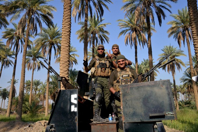 In this Saturday, Oct. 25, 2014 photo, Shiite militiamen patrol Jurf al-Sakhar, 70 kilometres south of Baghdad, Iraq. 