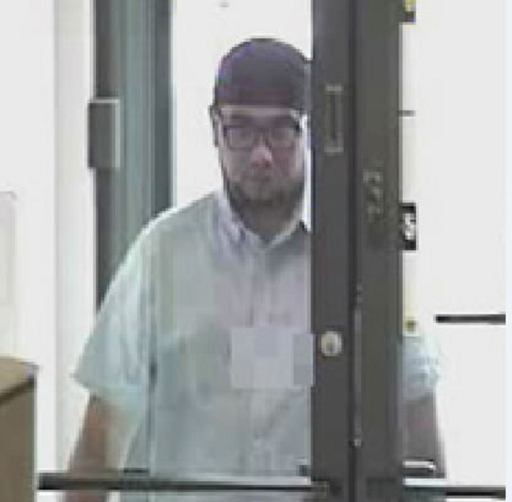 Police say this man pocketed cash from two banks in an elaborate theft in which he slipped off with $100 bills.