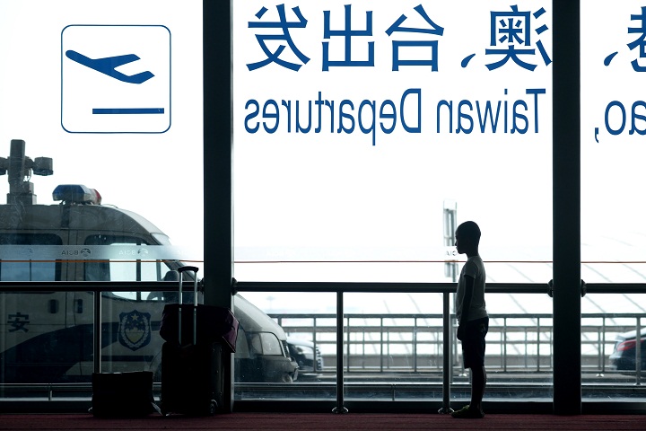 A boy looks out the window as he waits at Beijing's international airport on July 29, 2014.