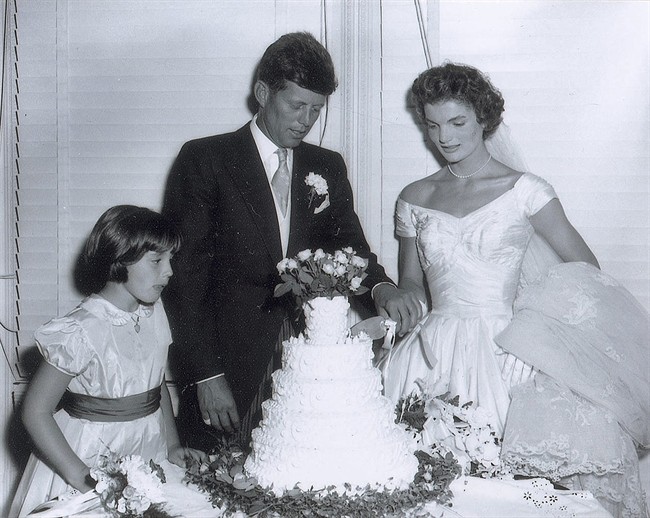 In this Sept. 12, 1953 photo released by RR Auction, John F. Kennedy, Jr., and his new bride Jacqueline cut the wedding cake at their reception in Newport, R.I.