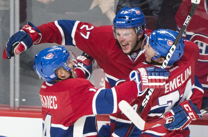 Montreal Canadiens' Alex Galchenyuk, centre, celebrates with teammates Tomas Plekanec, left, and Alexei Emelin after scoring against the Detroit Red Wings during third period NHL hockey action in Montreal, Tuesday, October 21, 2104.