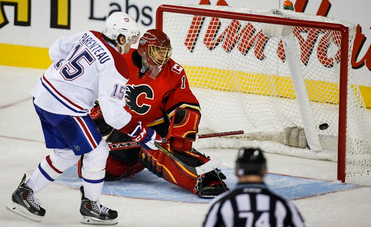 Montreal Canadiens Pierre-Alexandre Parenteau, left, scores the winning goal against Calgary Flames goalie Jonas Hiller, from Switzerland, during a shoot out in NHL hockey action in Calgary, Tuesday, Oct. 28, 2014.