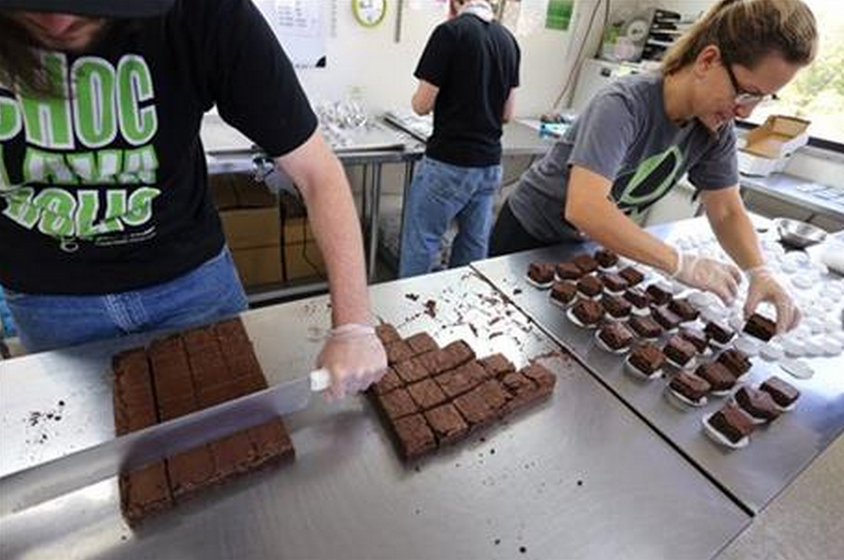 In this Sept. 26, 2014 photo, smaller-dose pot-infused brownies are divided and packaged at The Growing Kitchen, in Boulder. Recreational marijuana sellers are reaching out to novice cannabis users with edible products that impart a milder buzz and make it easy for inexperienced customers to find a dose they are less likely to regret taking. The marketing shift is the pot-industry equivalent of selling beer and wine alongside higher-alcohol options such as whiskey and vodka. (AP Photo/Brennan Linsley)
.