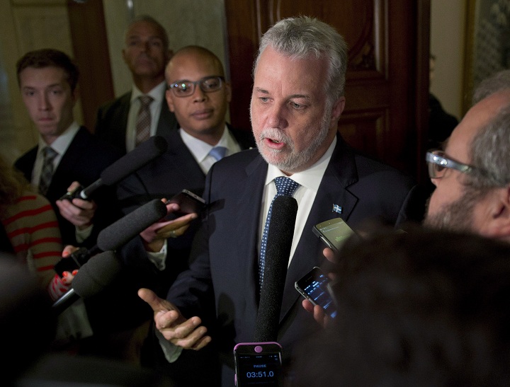 Quebec Premier Philippe Couillard responds to reporters' questions prior to question period at the legislature in Quebec City. 
