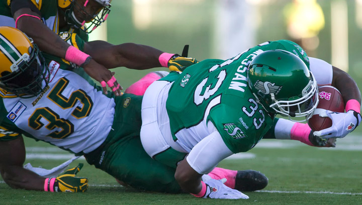 Saskatchewan Roughriders running back Jerome Messam reaches for extra yards after being tackled by Edmonton Eskimos linebacker Rennie Curran during the third quarter of CFL football action in Regina, Sask., Sunday, October 19, 2014. The Eskimos downed the Riders 24-19.