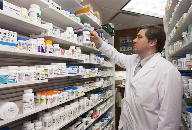 Pharmacist Denis Boissinot checks a bottle on a shelf at his pharmacy in Quebec City.