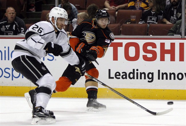Los Angeles Kings defenceman Slava Voynov (26) defends on a shot by Anaheim Ducks center William Karlsson, right during the second period of a preseason NHL hockey game, Sunday, Sept. 28, 2014, in Anaheim, Calif. 