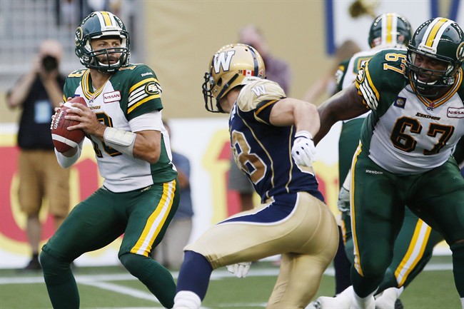 Edmonton Eskimos' quarterback Mike Reilly (13) gets set to throw against the Winnipeg Blue Bombers Ian Wild (38) during the first half of CFL action in Winnipeg on July 17, 2014. 