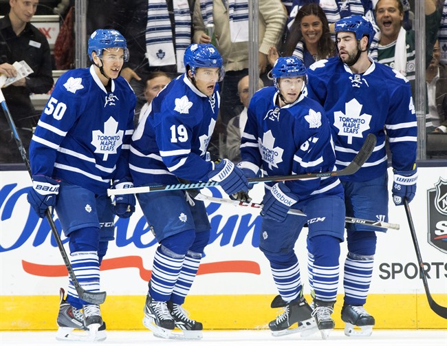 Toronto Maple Leafs' Stuart Percy (50), Joffrey Lupul (19), Brandon Kozun (67) and Troy Bodie celebrate after scoring on the Montreal Canadiens during first period NHL action in Toronto on Wednesday October 8, 2014.