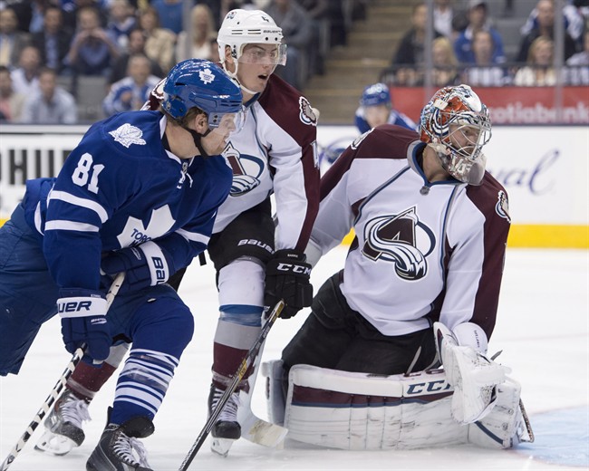Toronto Maple Leafs' Phil Kessel (81), Colorado Avalanche goaltender Semyon Varlamov and defenceman Tyson Barrie (4) look at the puck in the net for Kessel's game winning goal in NHL overtime action in Toronto on Tuesday October 14, 2014. THE CANADIAN PRESS/Frank Gunn.