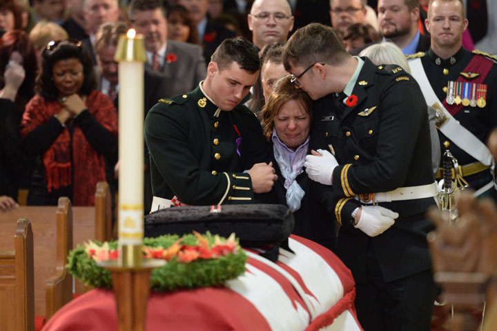 Kathy Cirillo is comforted in front of the coffin of her son Cpl. Nathan Cirillo at his regimental funeral service in Hamilton, Ontario, on Tuesday, Oct. 28, 2014.  THE CANADIAN PRESS/Nathan Denette.