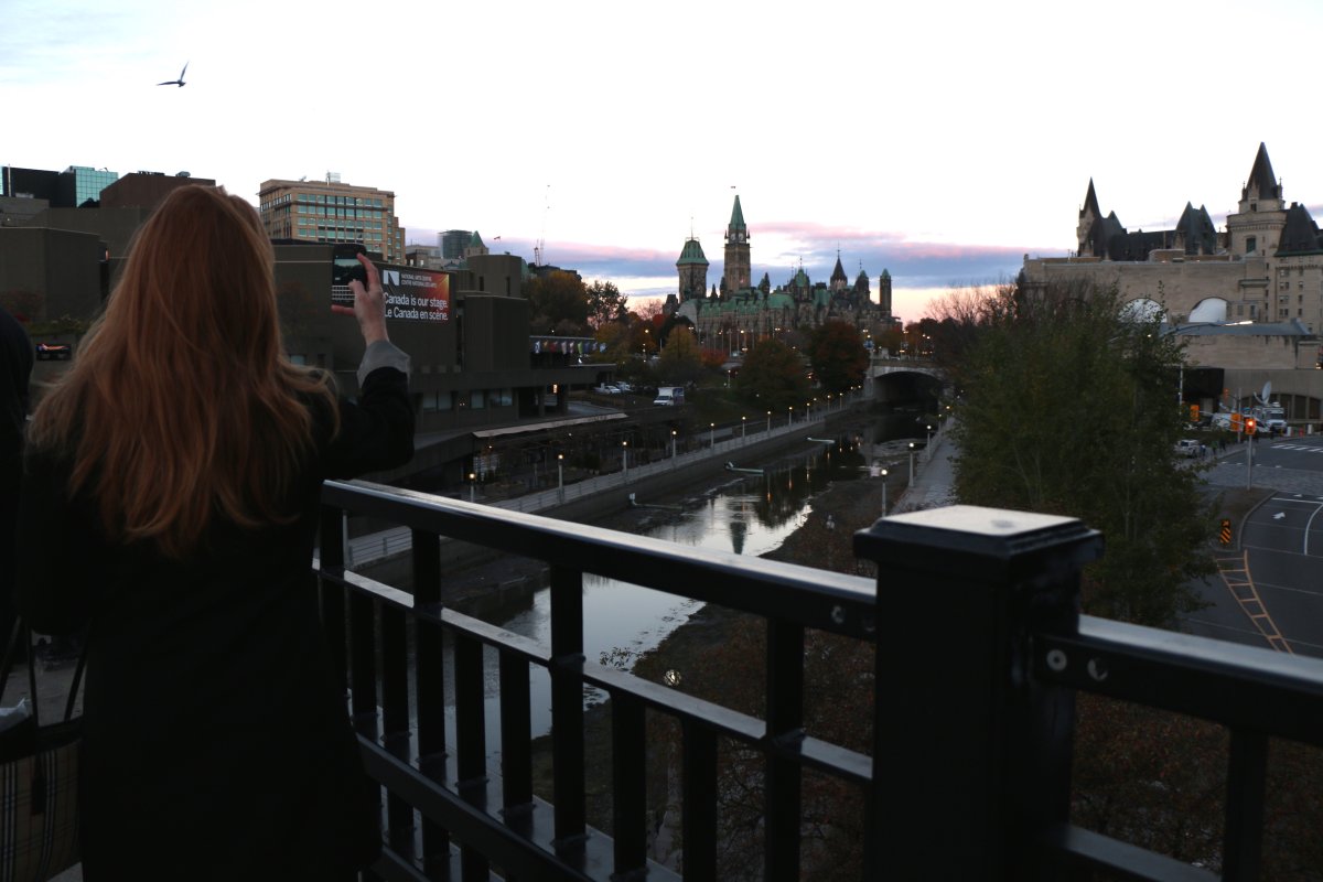 A woman takes photos of Parliament Hill on Thursday morning, Oct. 23.
