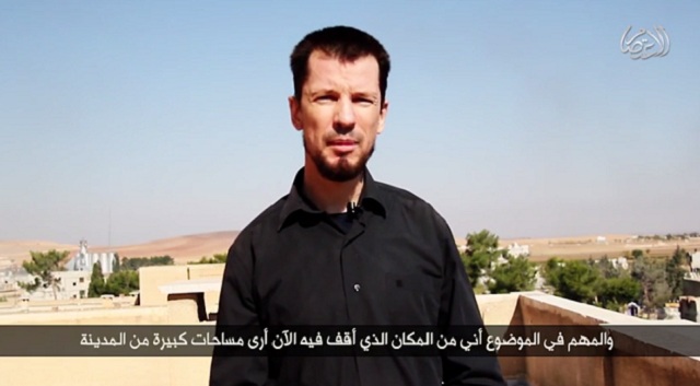 British ISIS hostage John Cantlie, in a propaganda video posted online Oct. 27. In the distance behind Cantlie, wheat silos with a Turkish flag on top can been seen, suggesting the video was taken near the border with Turkey.