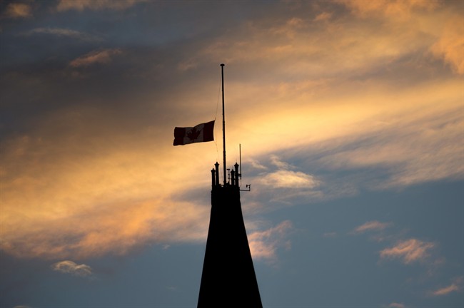 The Canadian flag flies at half mast atop the Peace Tower on Parliament Hill, one day after shootings in the nation's capital claimed the life of Cpl. Nathan Cirillo, 24, in Ottawa, on Thursday, Oct. 23, 2014.