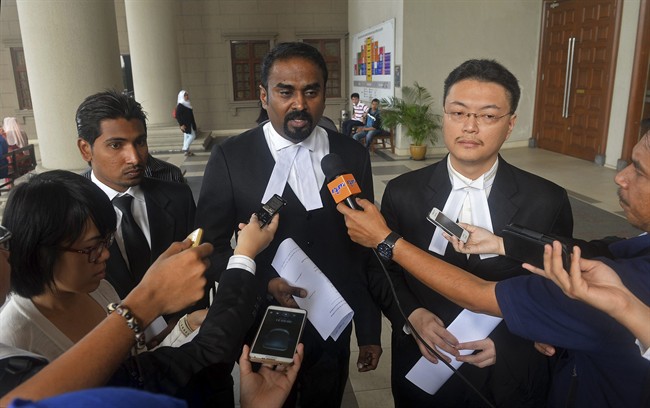 Malaysian lawyer Arunan Selvaraj, center, speaks to journalists outside a courthouse in Kuala Lumpur, Malaysia, Friday, Oct. 31, 2014. 