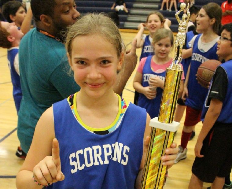 McKenna Peterson, 12, shows off one of her basketball trophies.