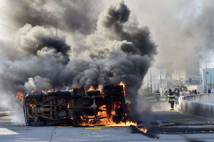 View of a blazing car after students set the Municipal Palace on fire in Chilpancingo, Guerrero on October 13, 2014, during a protest to demand the finding of the 43 peers missing since an attack by rogue officers earlier this month. 